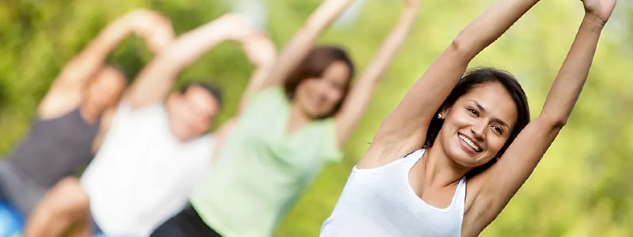 Personas practicando estiramientos al aire libre
