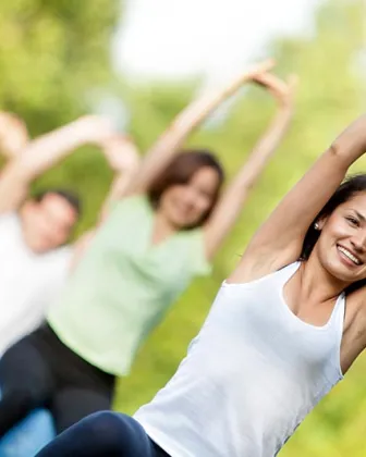 Personas practicando estiramientos al aire libre